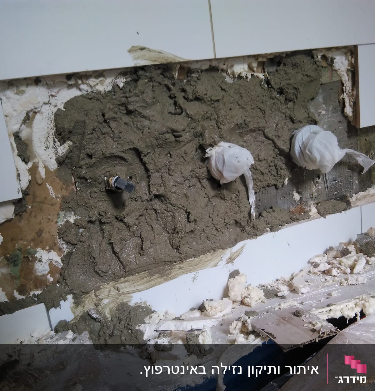 קיר פתוח עם צנרת מכוסה בטיח ותיקונים